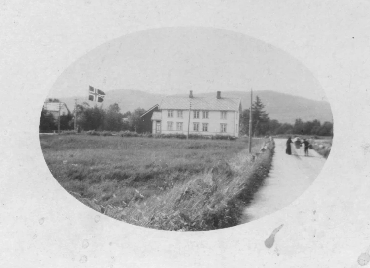 an old picture of a big house on the side of the road