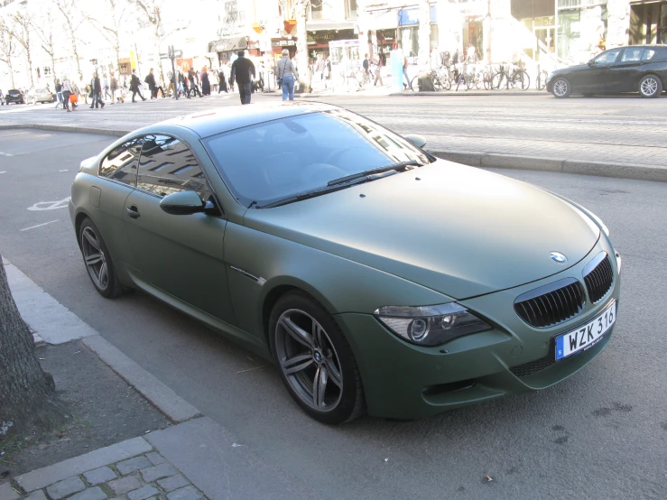 a green sports car parked on the side of the road