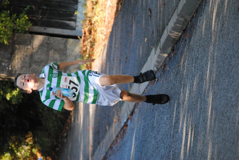 a boy running down the road in a marathon