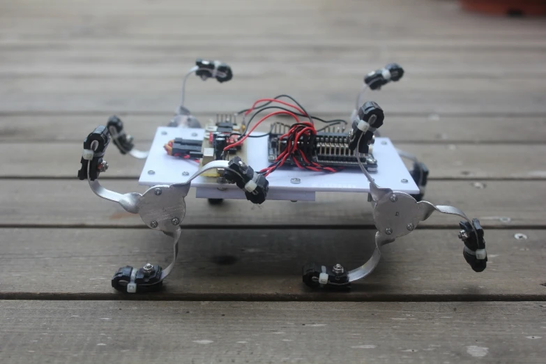 a robot kit on wooden floor with two cameras and wire