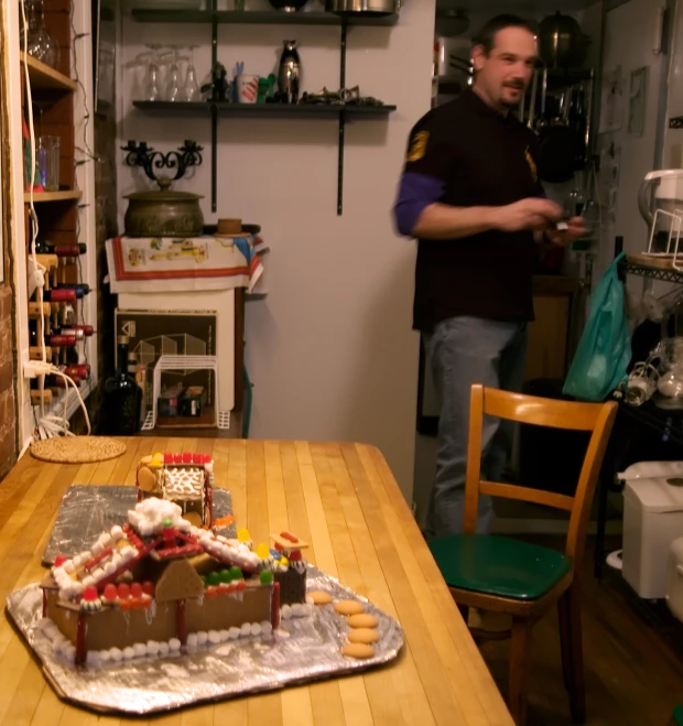 a man standing by a gingerbread house