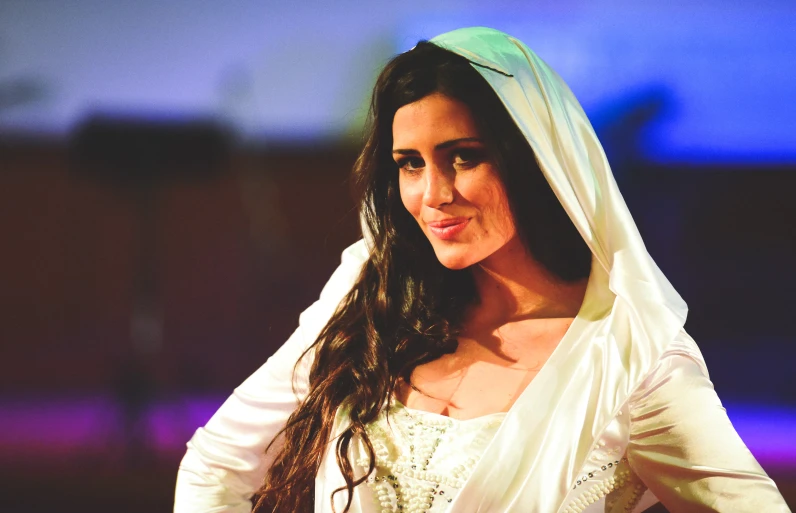 a woman in a wedding dress standing with her hands on her hips