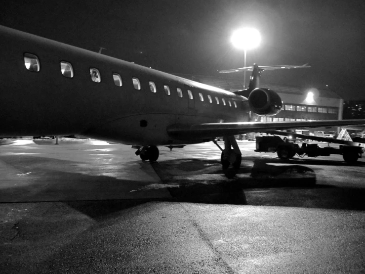 black and white image of a jet airplane on a runway