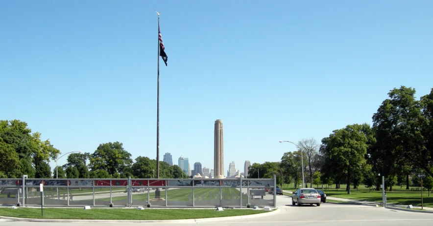 a gate leading to a flag pole and a car