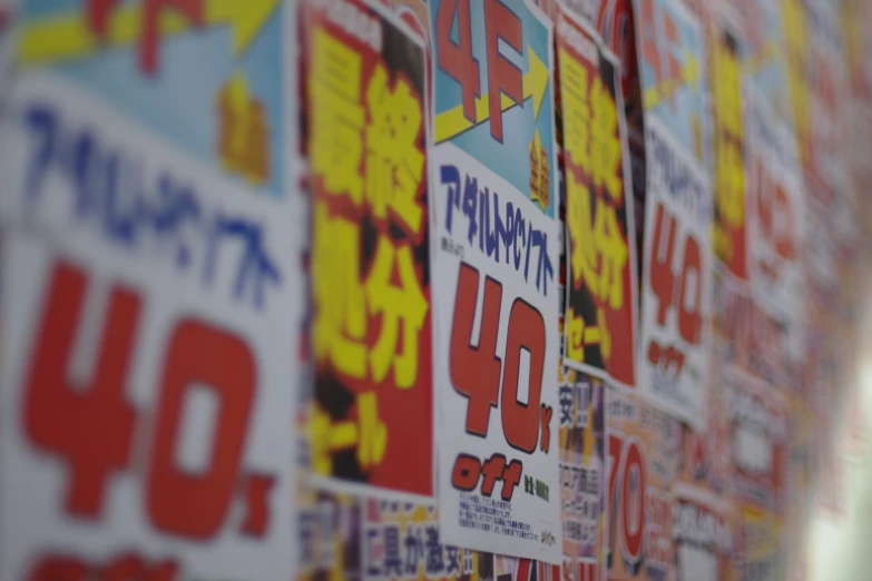 a wall full of posters and price signs