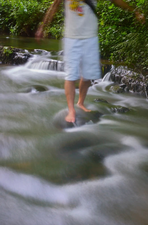 a blurry man standing in front of a waterfall