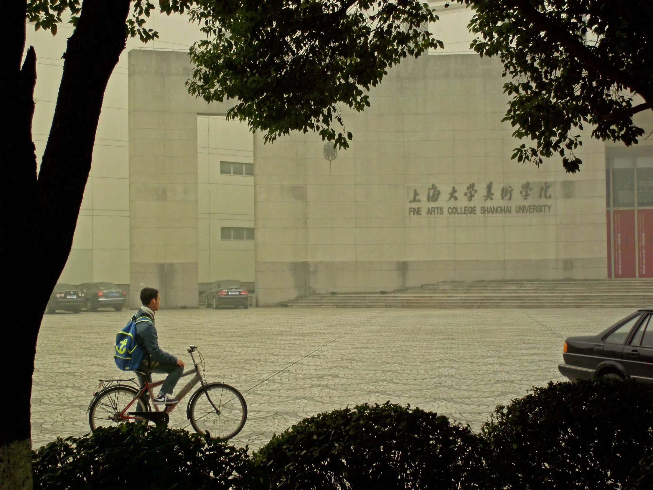 a person on a bike riding past the large building