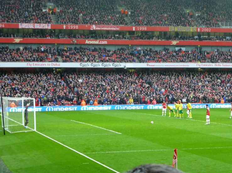 there are many men playing soccer in front of a crowd