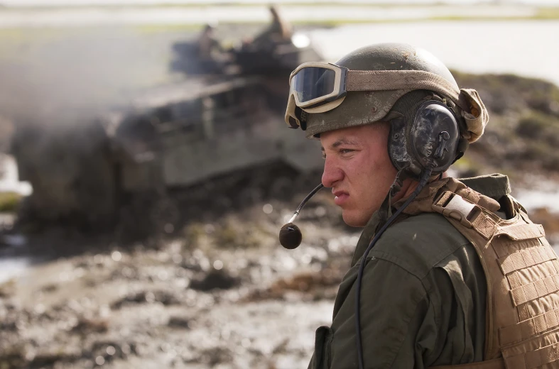 a soldier is standing with his headphones on