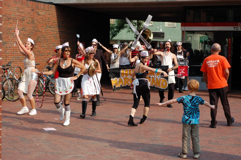 two women are dancing on the street surrounded by children