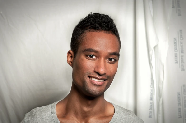 a young man with his hair styled in a mohawk and a grey shirt