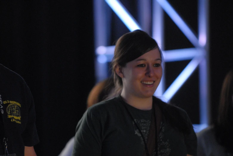 smiling woman wearing black in front of people at event