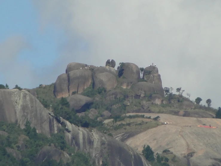 rock formations surrounded by forest under a cloudy sky