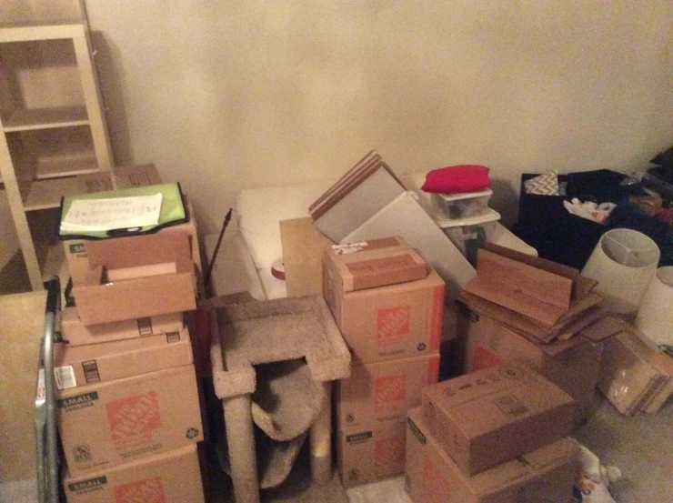 cardboard boxes piled up against a wall in a living room