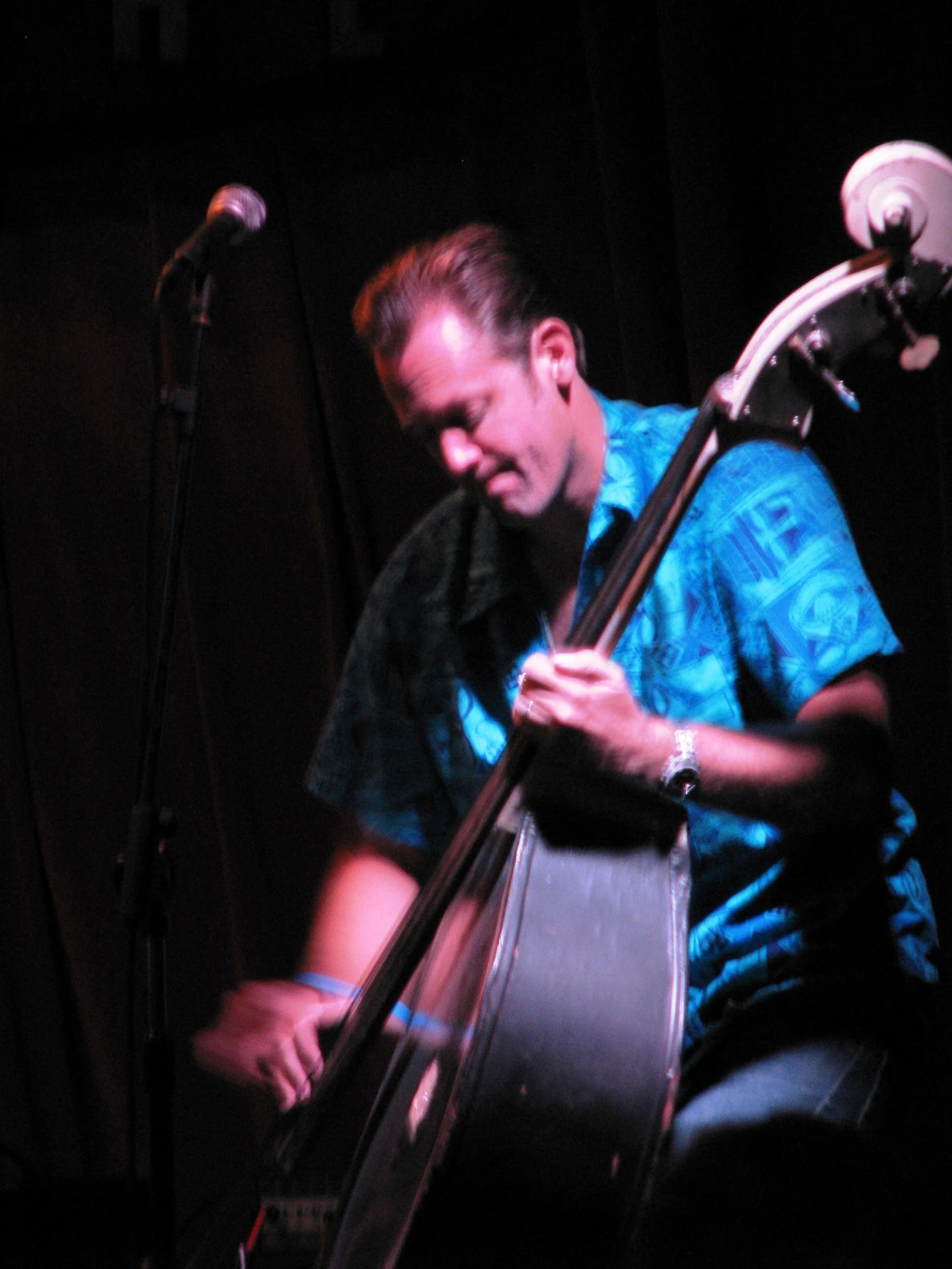 a boy leaning up holding a bass while sitting down