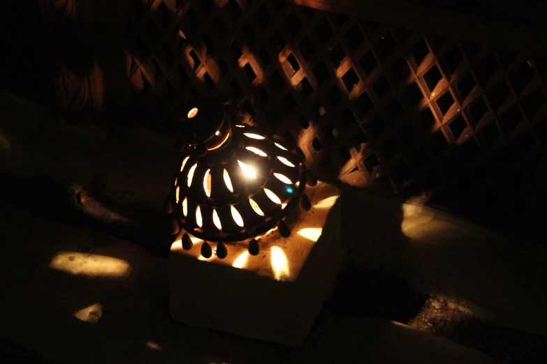 a lit candle sits in a circular bowl shaped object