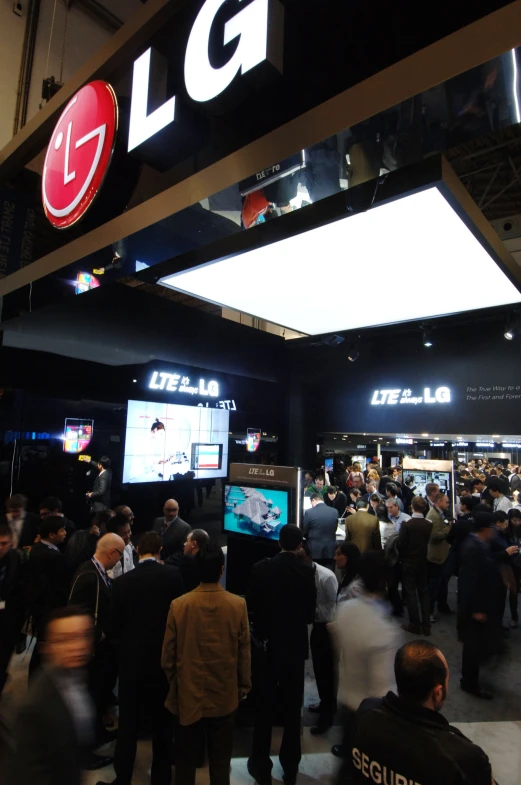 a group of people standing around in front of some televisions