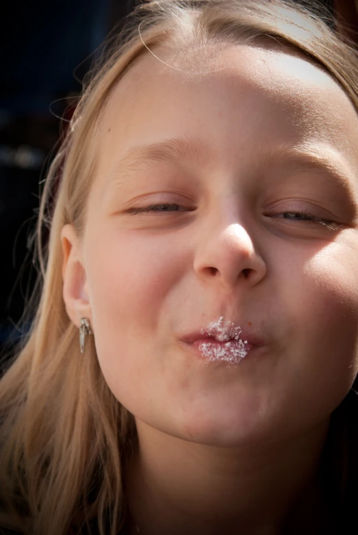a little girl with an aluminum plated nose and tongue