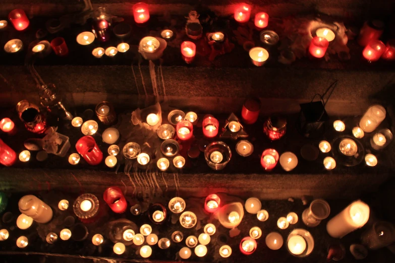 lighted candles in rows on a shelf