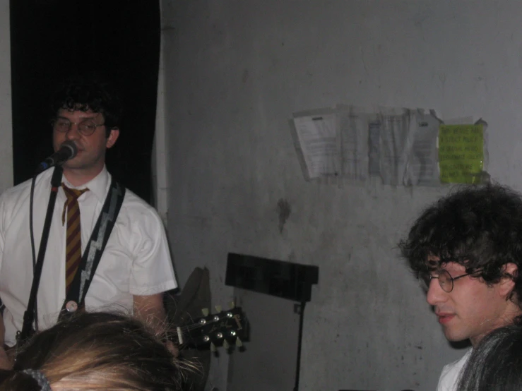 three people that are standing up with guitar