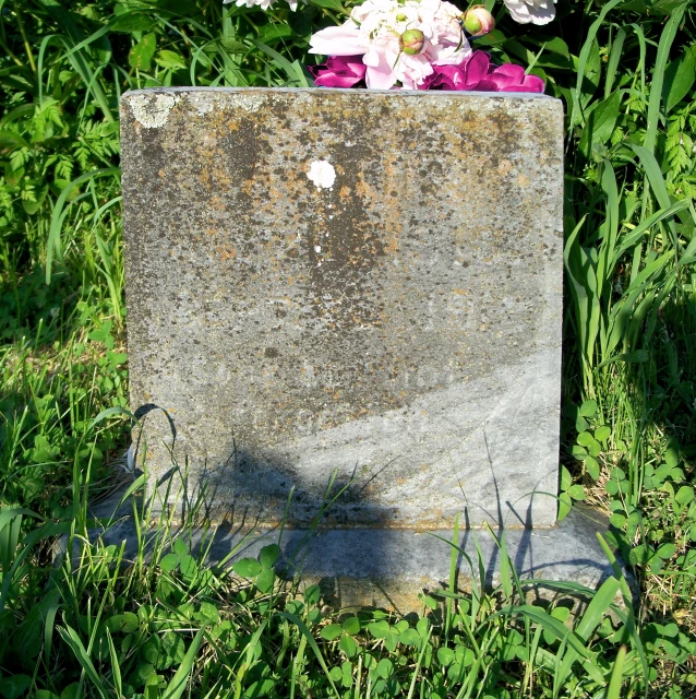 an old looking monument with flowers growing out of it