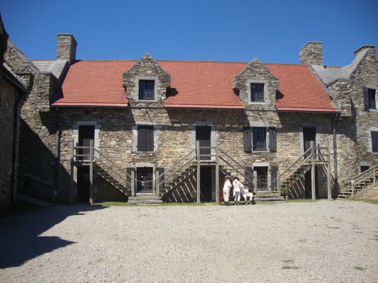 the old building with the brick roof has two people in it