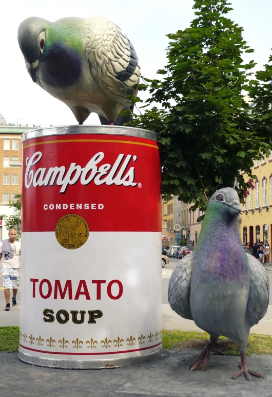 the bird is standing on top of a can and its own bird sits on top of it