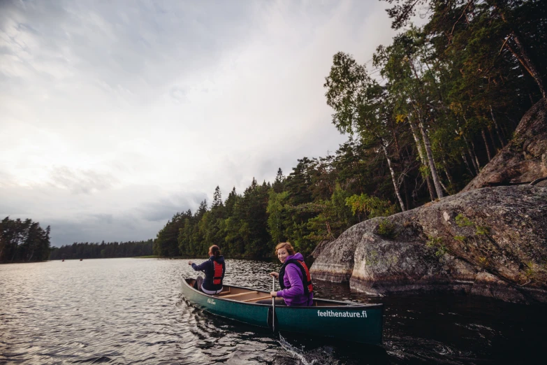 two people in small green boats on a lake