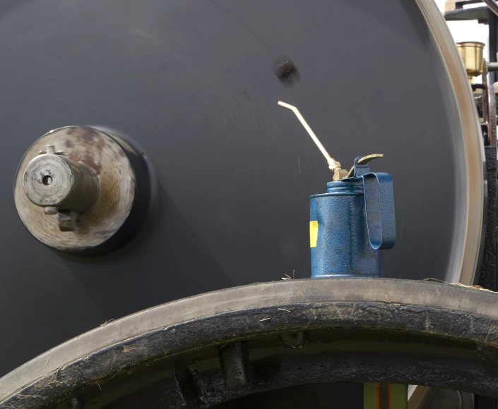 an old blue can is standing beside a wall mounted hook