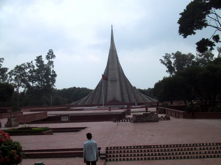 a man stands in front of a large building with many steps