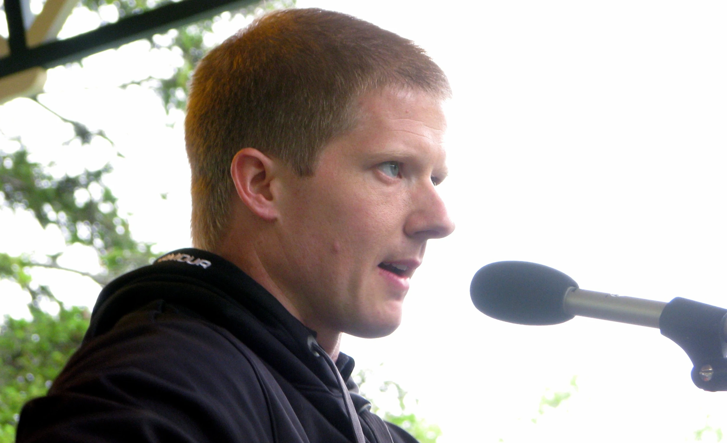 a man talking into a microphone over a microphone stand