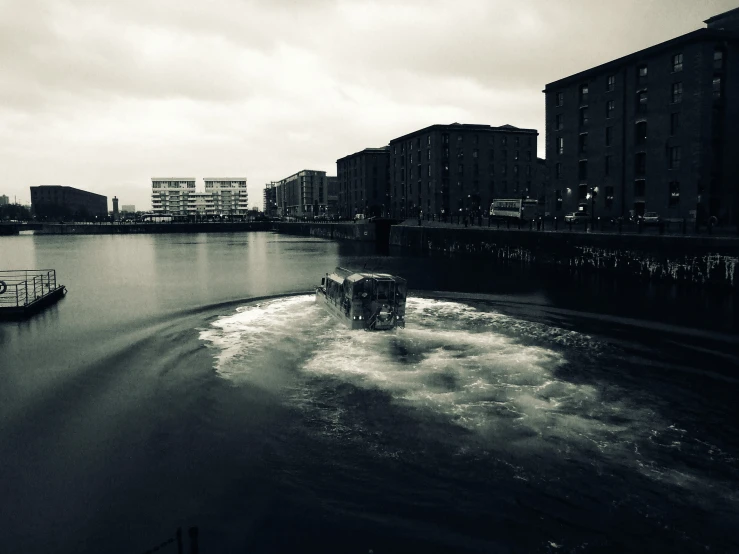 two boats are traveling on the water near buildings