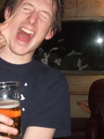 a young man with a beer making a laugh