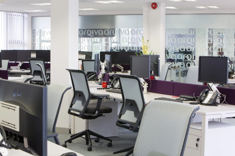 an office filled with desks and monitors