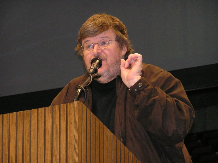 the man is standing at the microphone and making a speech