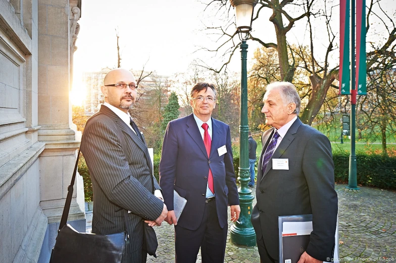 some very pretty men standing close together talking