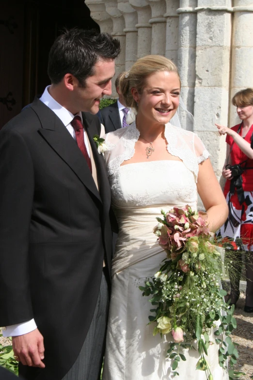 the newly married couple is in front of an old building