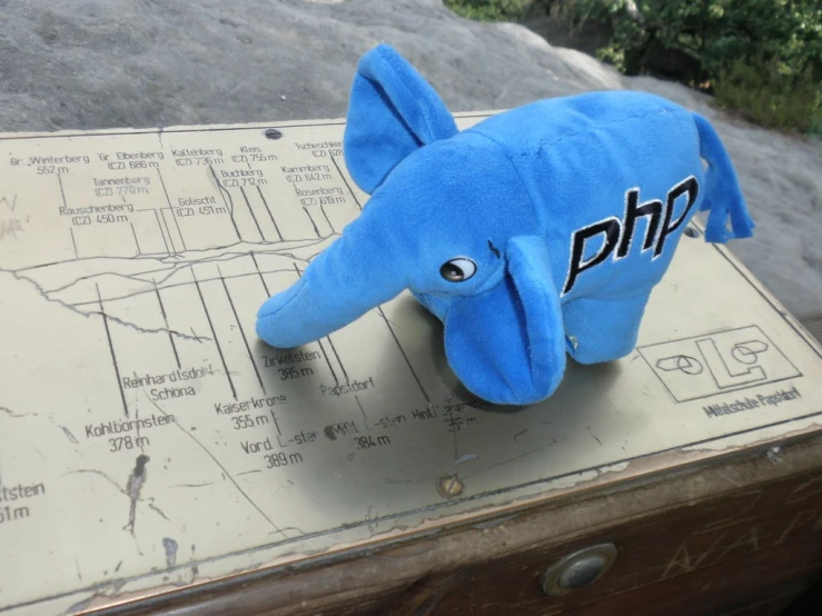 a blue elephant is sitting on a piece of paper