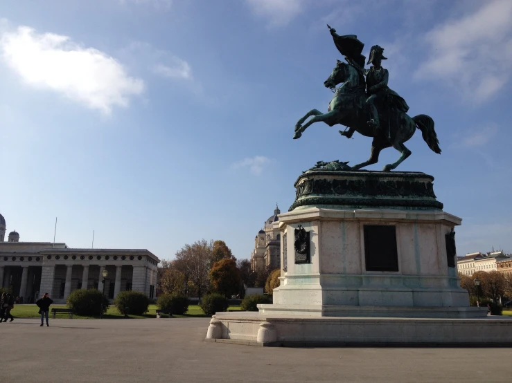 a man on a horse statue in a park