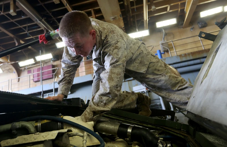 an army man working on the engine of his plane