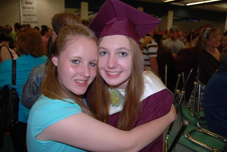 two young ladies hugging each other at graduation