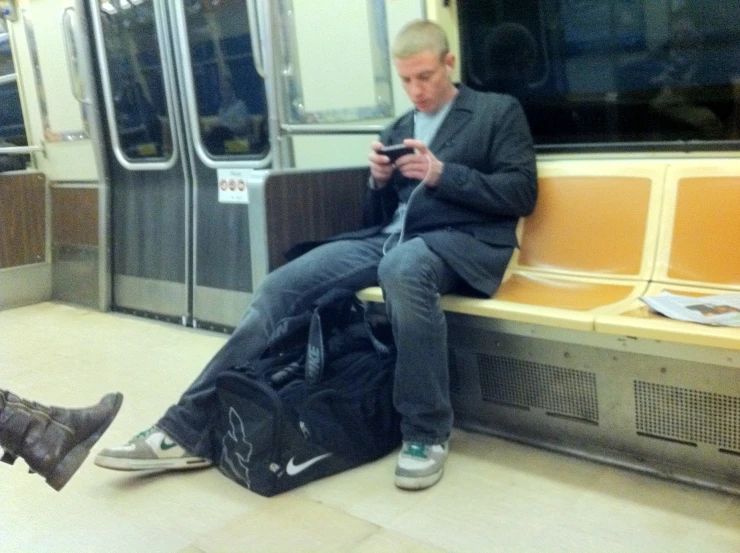 an old man sitting on a bench looking at his phone