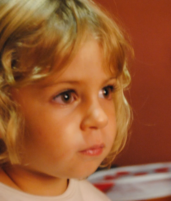 a small girl is wearing a bow in her hair