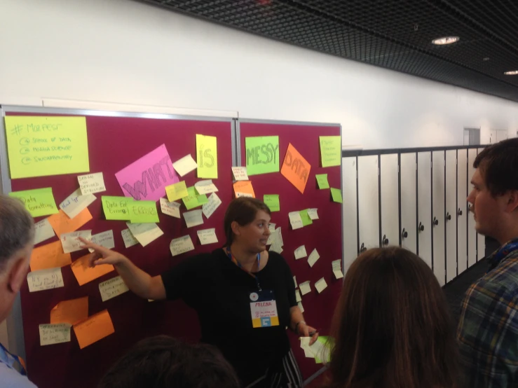 a man standing in front of a bulletin board full of notes