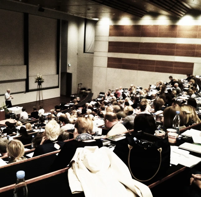 a large lecture hall filled with people and their books