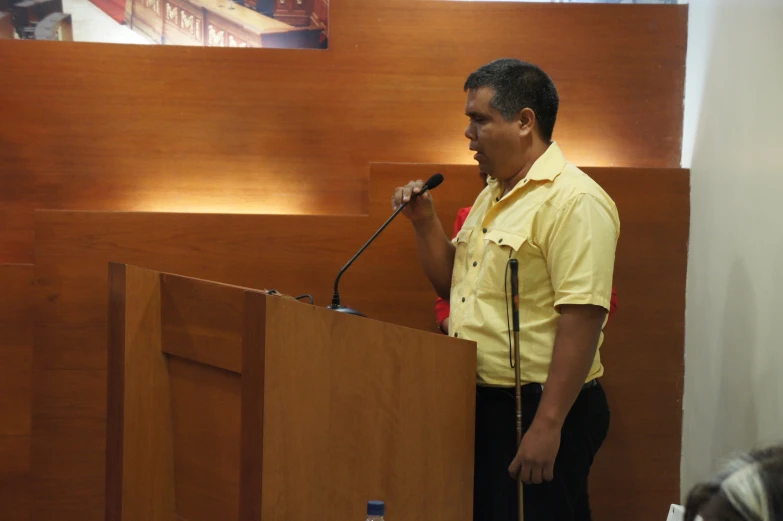 a man standing behind a podium with microphone