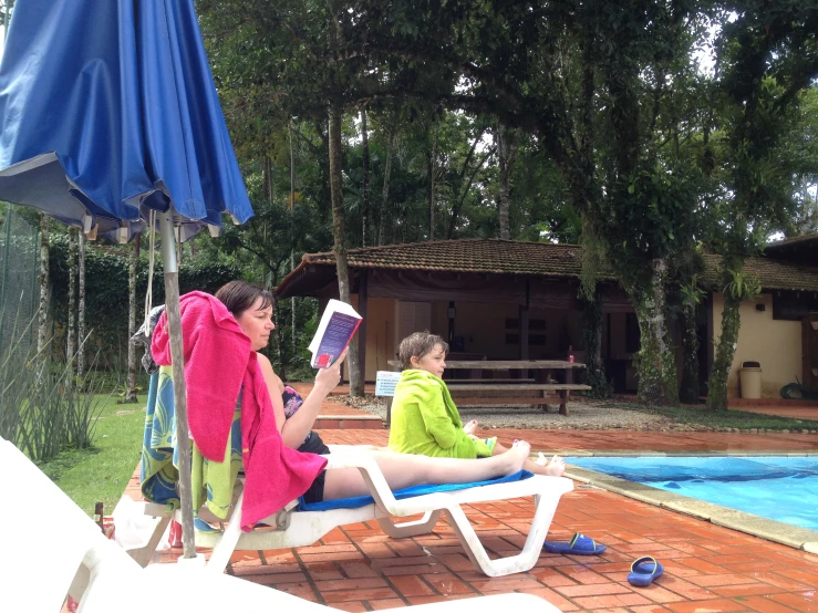 two women are lounging in front of a pool