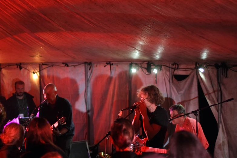 a group of people singing into microphones and guitar