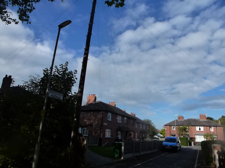 the sky is cloudy in the early afternoon and this is a suburban street