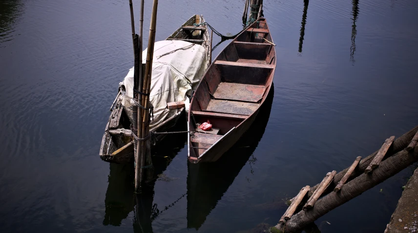 a small boat is docked with several smaller boats